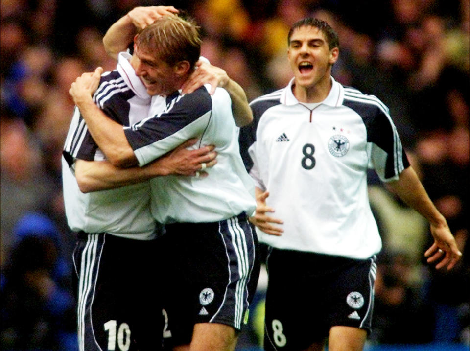 FILE - In this Oct. 7, 2000 file photo Germany's Dietmar Hamann, left, is embraced by teammate Marko Rehmer, center, while Sebatian Deisler celebrates after the opening goal during the group nine World Cup qualification match England versus Germany at Wembley stadium in London. The last game at the old Wembley turned out to be Kevin Keegan's last game in charge of England's national team. The coach decided to quit while seeking privacy in a bathroom cubicle shortly after Dietmar Hamann's free kick squirmed through the hands of goalkeeper David Seaman. (AP Photo/Christof Stache, File)