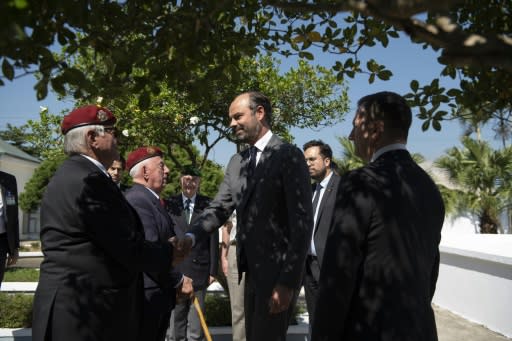 Prime Minister Edouard Philippe (C) shakes hands with war veterans in Dien Bien Phu, where 13,000 people were killed in the 1954 battle