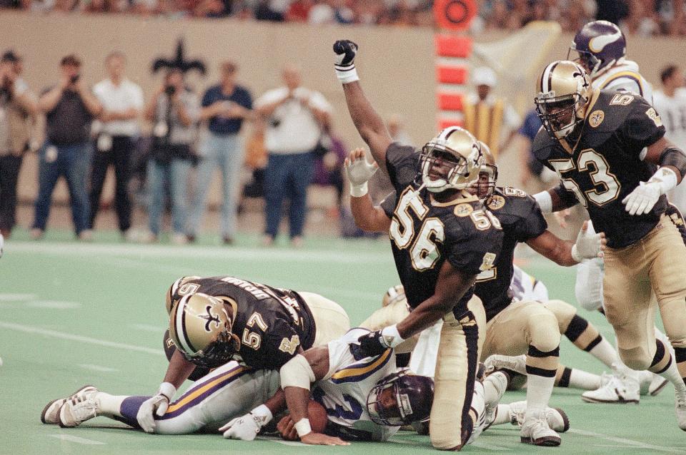 Saints linebacker Pat Swilling (56) raises his fist after stopping Herschel Walker for a 1-yard-loss in the first half, Sept. 22, 1991 in New Orleans. Joining Swilling on the play are fellow linebackers Rickey Jackson (57), Sam Mills, rear, and Vaughan Johnson (53). The Saints defeated the Vikings 26-0.