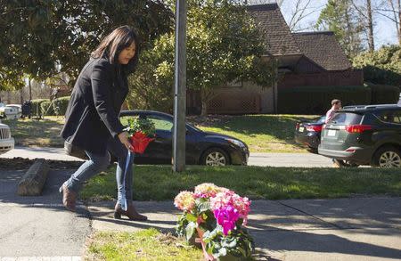 A woman places flowers near a building where three young Muslims were killed on Tuesday, in Chapel Hill, North Carolina February 11, 2015. REUTERS/Chris Keane