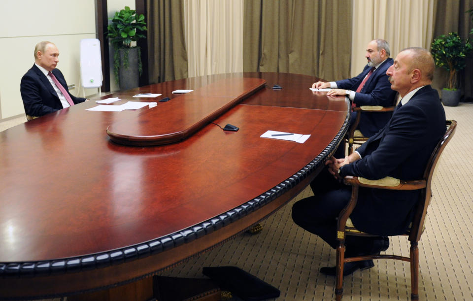 Russian President Vladimir Putin, left, Azerbaijan's President Ilham Aliyev, right, and Armenia's Prime Minister Nikol Pashinyan talk during their meeting in the Bocharov Ruchei residence in the Black Sea resort Sochi, Russia, Friday, Nov. 26, 2021. Russian President Vladimir Putin is hosting the leaders of Armenia and Azerbaijan for talks. The meetings mark a one-year anniversary of a Moscow-brokered peace deal that ended fighting in the separatist region of Nagorno-Karabakh. (Mikhail Klimentyev, Sputnik, Kremlin Pool Photo via AP)