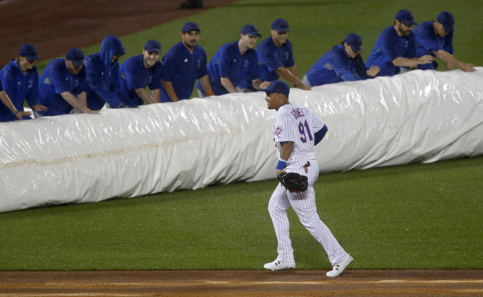 NEW YORK, NEW YORK - JUNE 13:  Carlos Gomez #91 of the New York Mets looks on as the ground crew roll out the tarp prior to the start of the ninth inning against the St. Louis Cardinals at Citi Field on June 13, 2019 in New York City. (Photo by Jim McIsaac/Getty Images)