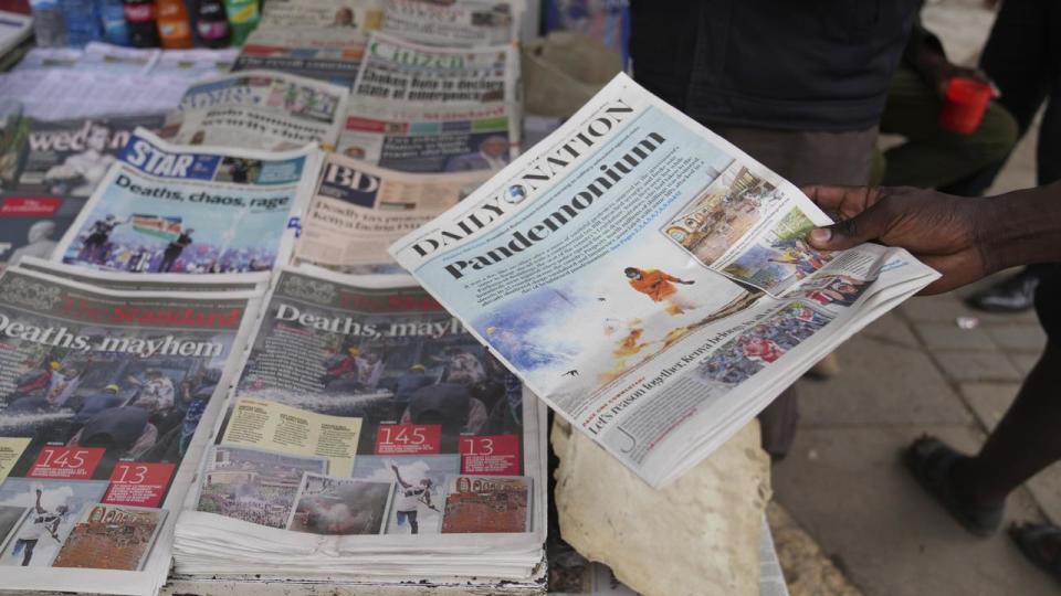 Kenyans discuss the protest as they read newspapers in Nairobi