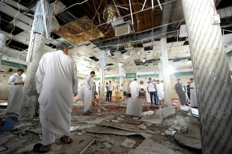 Saudi Shiites inspect the debris of a mosque following a deadly bombing carried out Sunni extremists of the Islamic State group on May 22, 2015