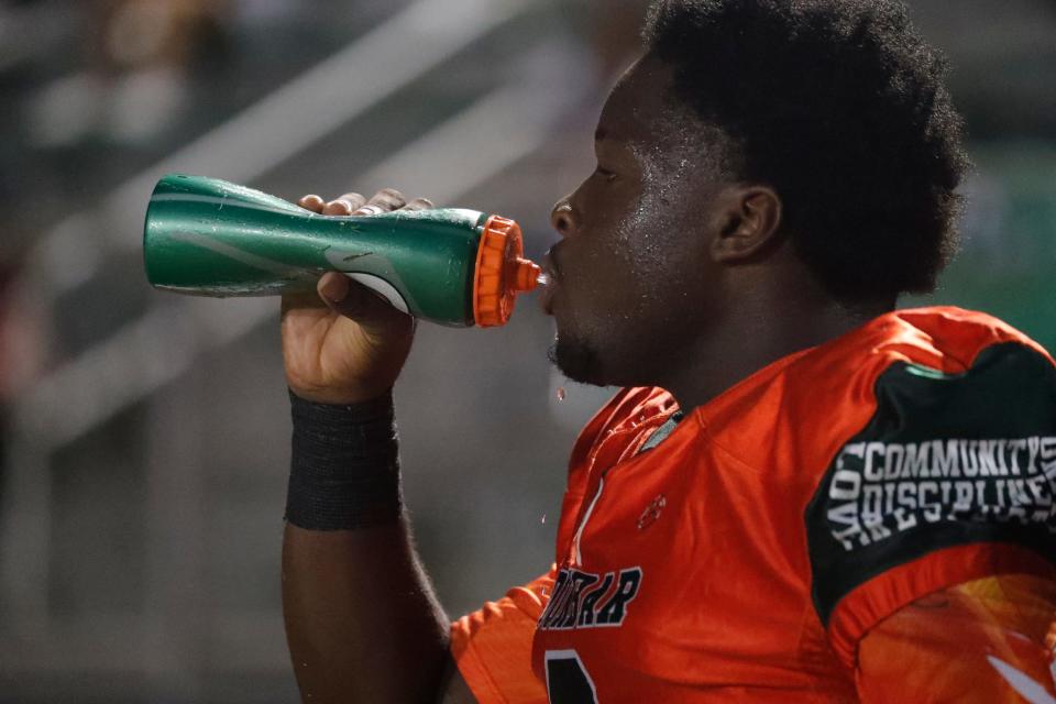 Dunbar High School football player La'viris Singleton takes a water break between game action Tuesday, October 18, 2022. Dunbar hosted Cypress Lake for a regular season football matchup. The game had been re-scheduled after the impact of Hurricane Ian forced schools to postpone activities. 