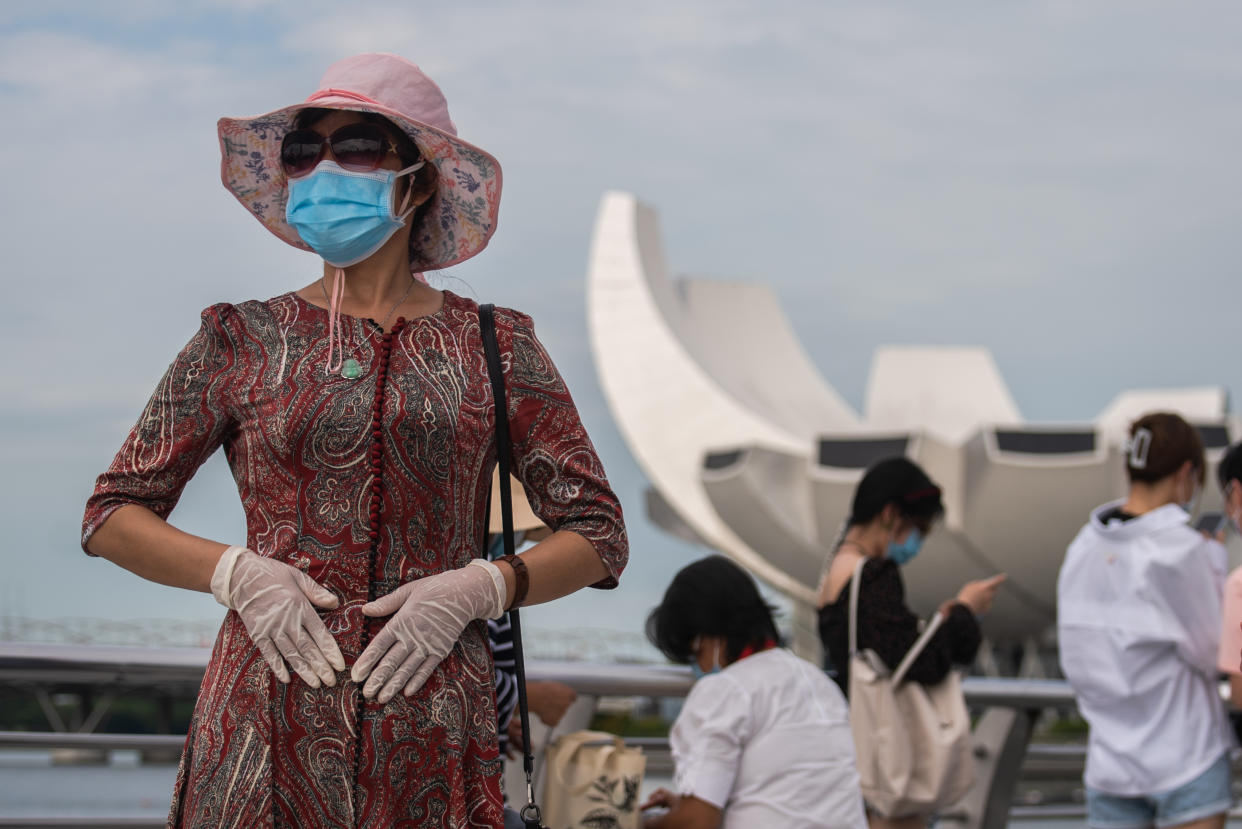 A woman wearing 2 masks and gloves at Singapore's Marina Bay on Sunday, 1st August 2021 in SIngapore. Community cases have risen steadily as the largest Covid-19 cluster that began in Singapore's main fishing port weeks ago has since reported more than 1000 cases linked to it yesterday. (Photo by Joseph Nair/NurPhoto via Getty Images)