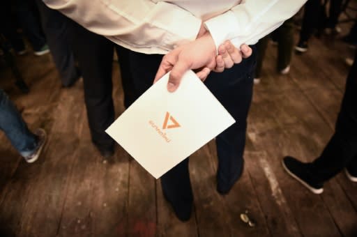 A supporter holds a leaflet with the logo of Thai political party Future Forward, which critics suggested showed links to the Illuminati