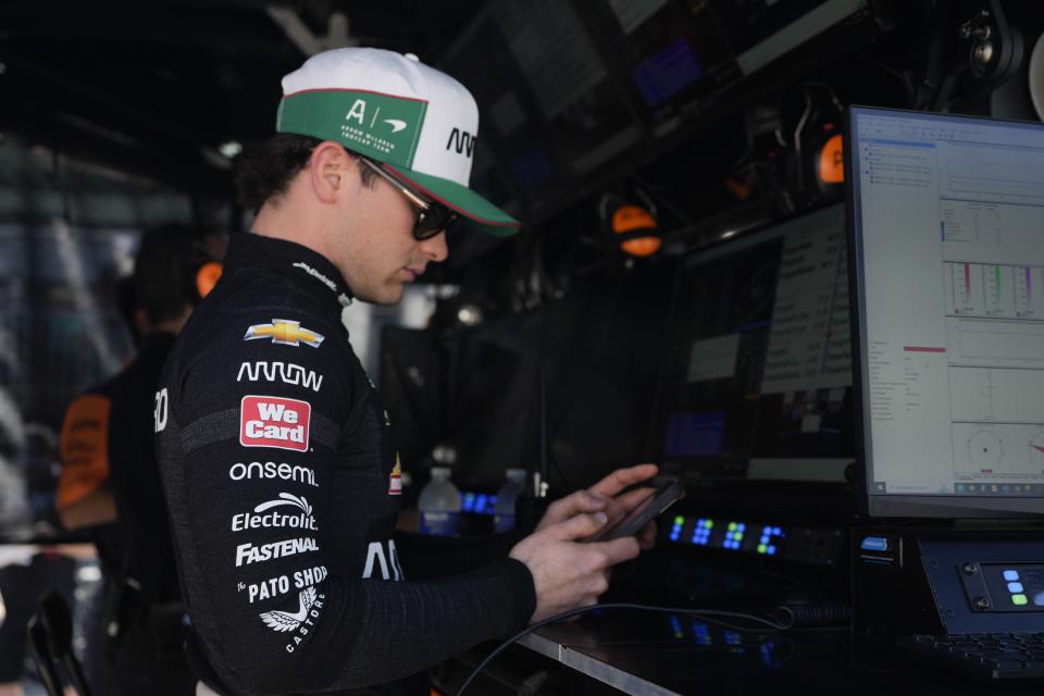 Pato O'Ward, of Mexico, looks at his phone before a practice session for the Indianapolis 500 auto race at Indianapolis Motor Speedway, Friday, May 24, 2024, in Indianapolis. (AP Photo/Darron Cummings)