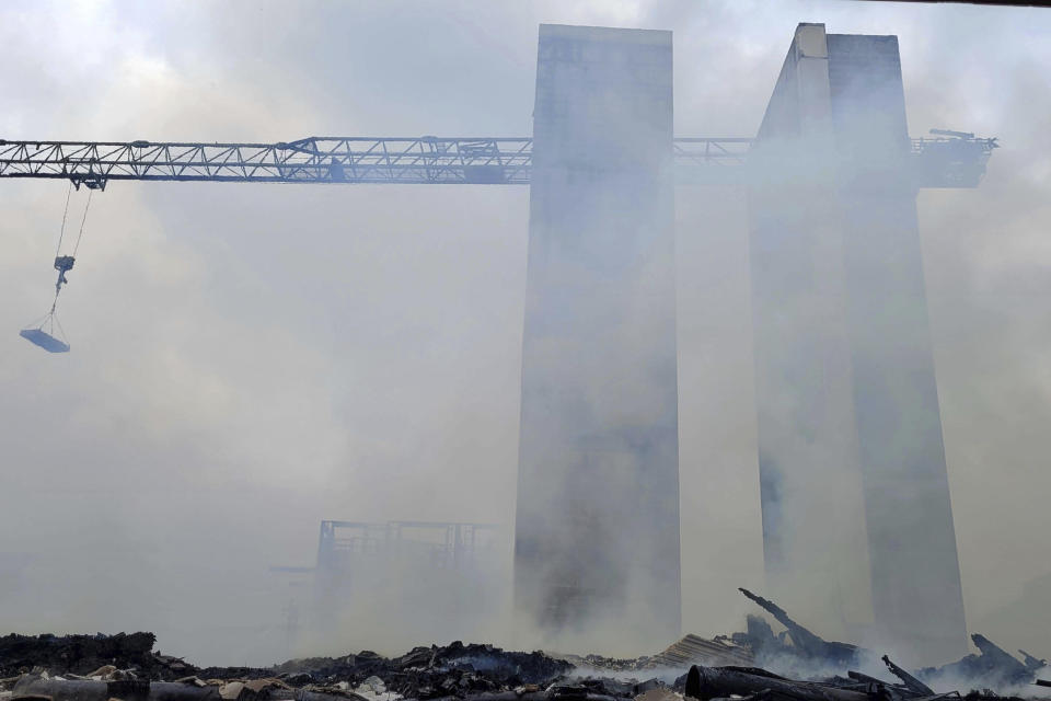 Firefighters work the scene of a massive fire spread across at least two structures and threatened others in Charlotte's South Park neighborhood, North Carolina, Thursday morning, May 18, 2023. (Khadejh Nikouyeh/The Charlotte Observer via AP)