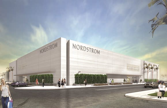 White-stone Nordstrom retail store as seen from outside, with shoppers walking on sidewalks.