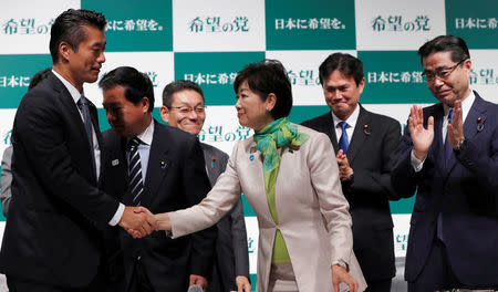 Tokyo Governor Yuriko Koike (C), the leader of her new Party of Hope, shakes ahnds with her party member Goshi Hosono (L), a former environment minister as Masaru Wakasa (R), a former prosecutor who left the ruling Liberal Democratic Party claps his hands during a news conference to announce the party's campaign platform in Tokyo, Japan, September 27, 2017. REUTERS/Issei Kato