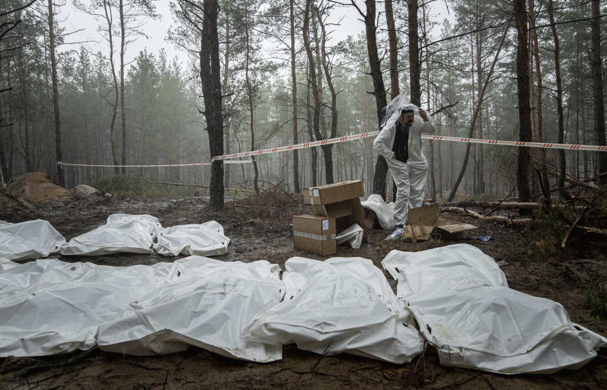 Bags with dead bodies are seen during the exhumation in the recently retaken area of Izium, Ukraine, Friday, Sept. 16, 2022. Ukrainian authorities discovered a mass burial site near the recaptured city of Izium that contained hundreds of graves. It was not clear who was buried in many of the plots or how all of them died, though witnesses and a Ukrainian investigator said some were shot and others were killed by artillery fire, mines or airstrikes. (AP Photo/Evgeniy Maloletka)