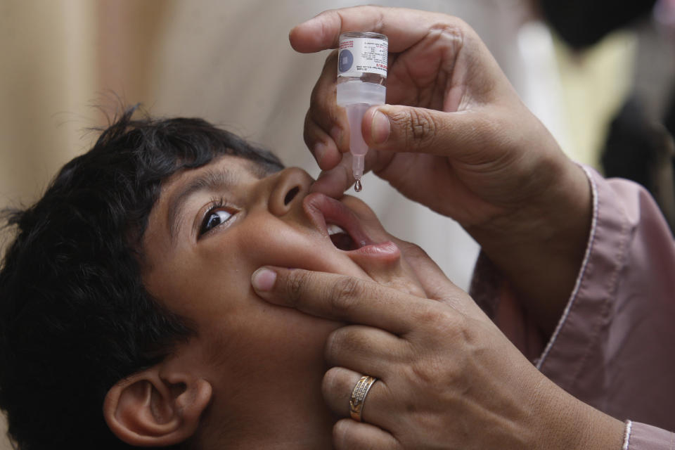 A health worker gives a polio vaccine to a child in Karachi, Pakistan, Monday, May 23, 2022. Pakistan launched a new anti-polio drive on Monday, more than a week after officials detected the third case so far this year in the country's northwestern region bordering Afghanistan. (AP Photo/Fareed Khan)