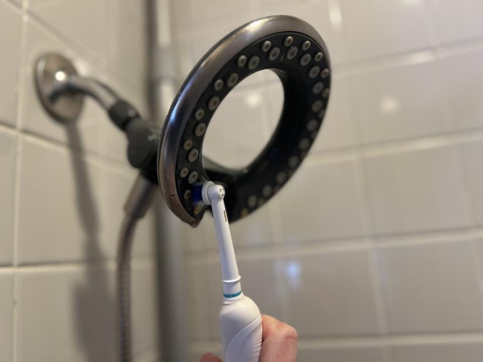 Use an electric toothbrush to clean any remaining residue. It also helps maintain your showerhead between deep-cleans.<p>Emily Fazio</p>