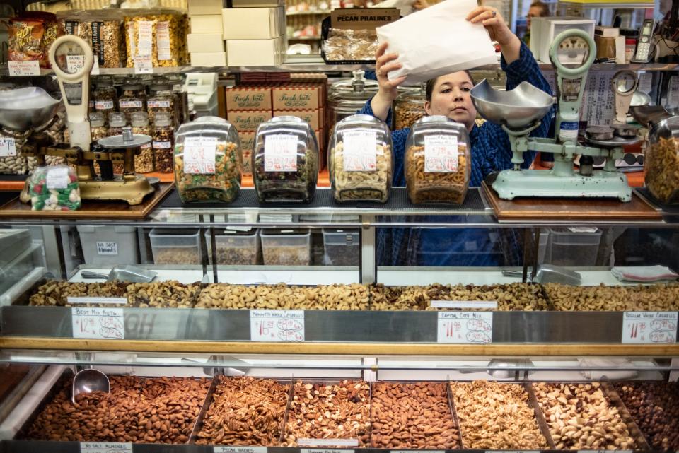 Michelle McLain of The Peanut Shop weighs out nuts Monday, Jan. 27, 2020.