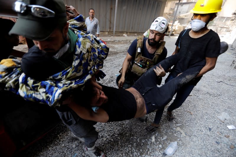 Demonstrators carry a wounded man during the ongoing anti-government protests in Baghdad