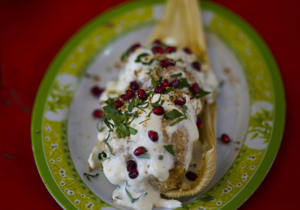 Un plato de chiles en nogada versión tamal, expuesto en la feria de tamales en el vecindario de Iztapalapa, en la Ciudad de México, el 27 de enero de 2023. Chiles en nogada es un plato mexicano de chiles poblanos rellenos de picadillo coronados con una crema a base de nuez llamada nogada, granada y perejil, y se sirve a temperatura ambiente. Está ampliamente considerado como el plato nacional de México. (AP Foto/Fernando Llano)