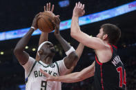 Milwaukee Bucks' Bobby Portis, left, shoots on Toronto Raptors' Svi Mykhailiuk during the first half of an NBA basketball game Thursday, Dec. 2, 2021, in Toronto. (Chris Young/The Canadian Press via AP)