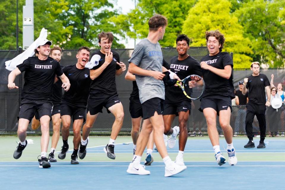 Jack Loutit’s Kentucky’s teammates rush to celebrate with him after his comeback victory at No. 5 singles clinched the Wildcats’ second-round win against Illinois on Saturday at the Boone Tennis Complex.