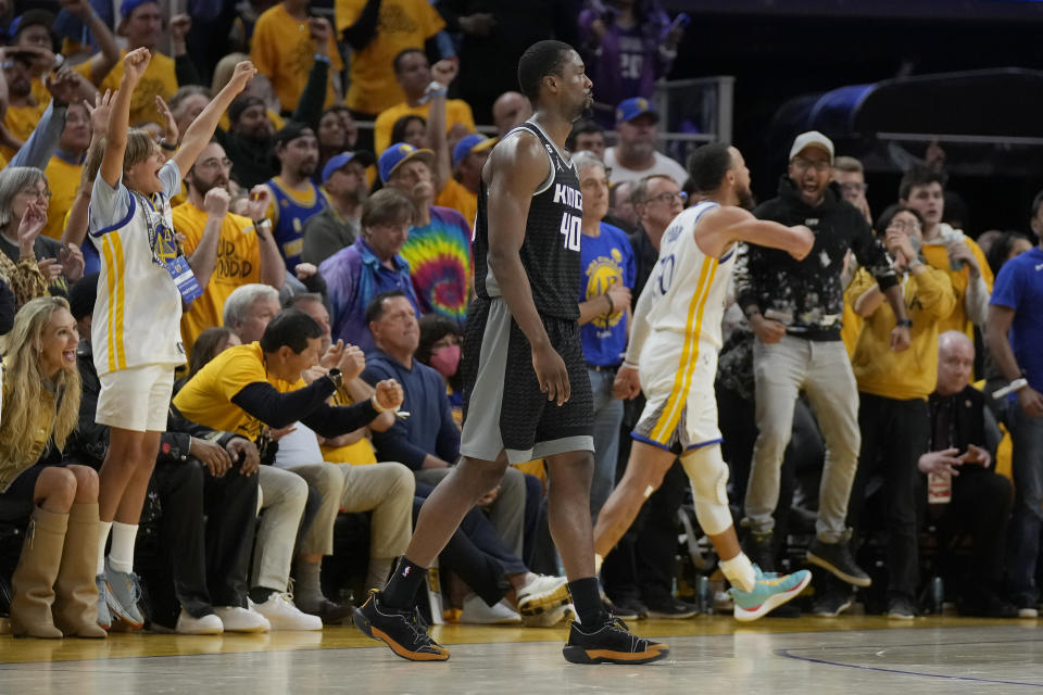 Sacramento Kings forward Harrison Barnes, foreground, reacts after missing a basket at the second-half buzzer as Golden State Warriors guard Stephen Curry (30), right, celebrates with fans during Game 4 in the first round of the NBA basketball playoffs in San Francisco, Sunday, April 23, 2023. (AP Photo/Jeff Chiu)
