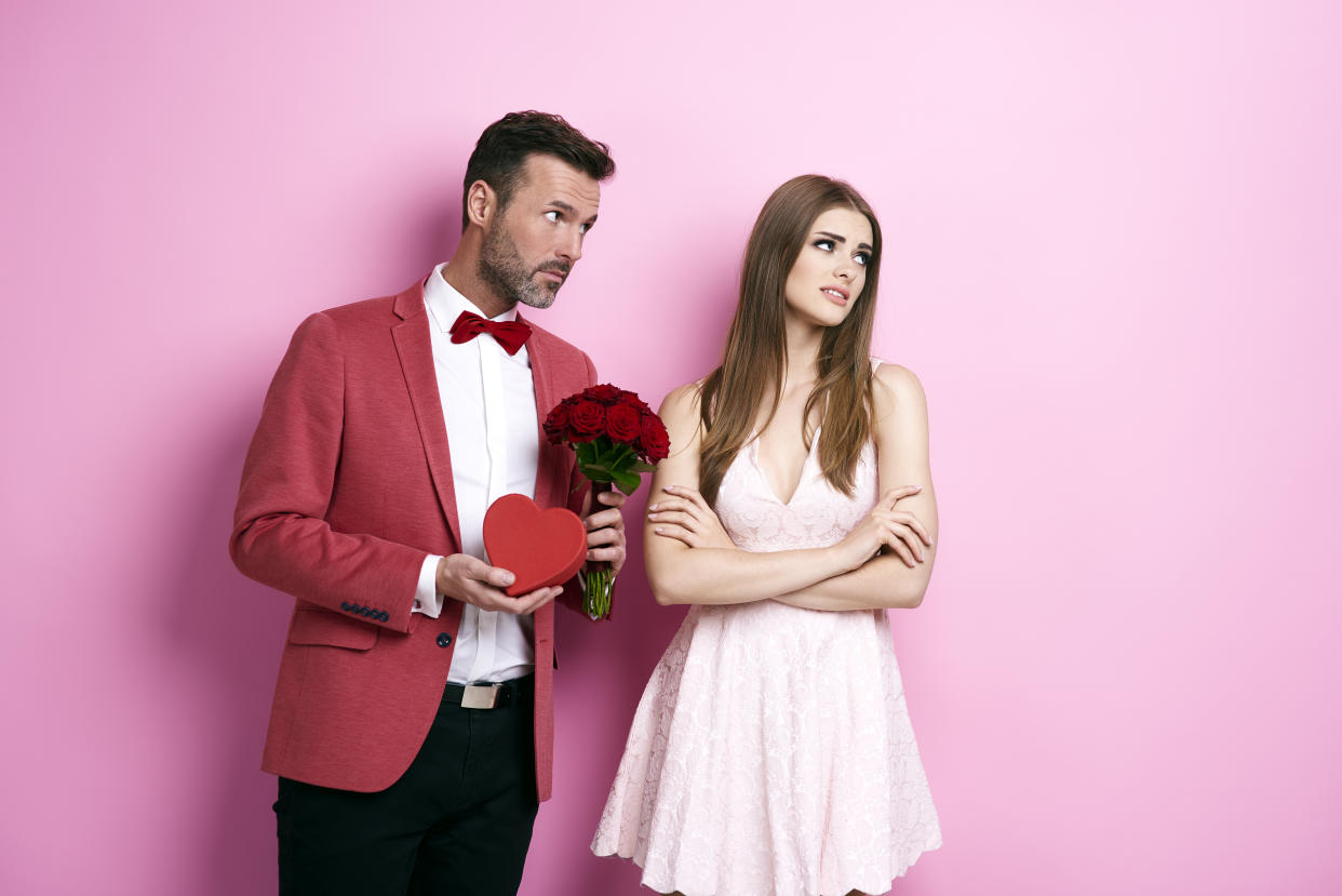 Man with bunch of rose and chocolate box apologizing fiance