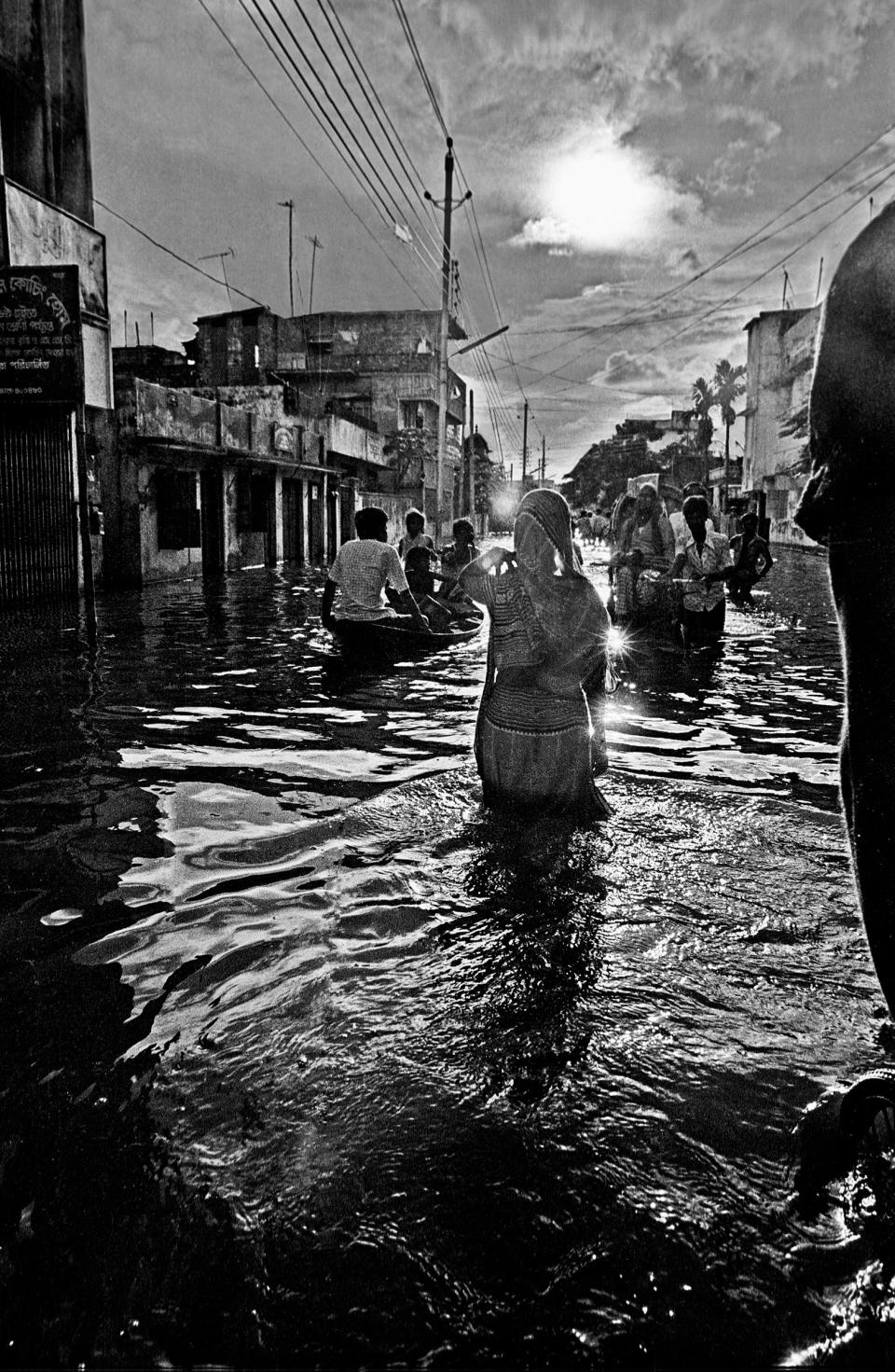 Woman wading in flood waters, Kamalapur, Dhaka, Bangladesh. 1988.