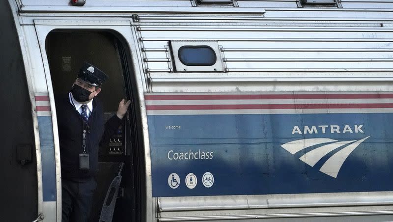 A conductor makes sure all is clear as the Amtrak Downeaster passenger train pulls out of the station in Freeport, Maine, on Dec. 14, 2021. Utah, Idaho and Nevada transportation officials are seeking funds to study a restoration of rail service from Boise to Las Vegas via Salt Lake City.