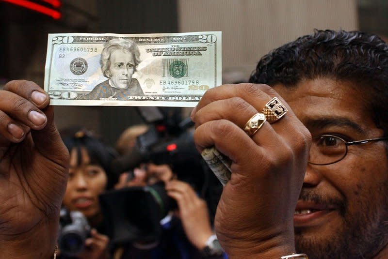 A street vendor gets a up close look on October 9, 2003, at the new redesigned $20 notes after they were released into circulation in New York's Times Square district. File Photo by Ezio Petersen/UPI