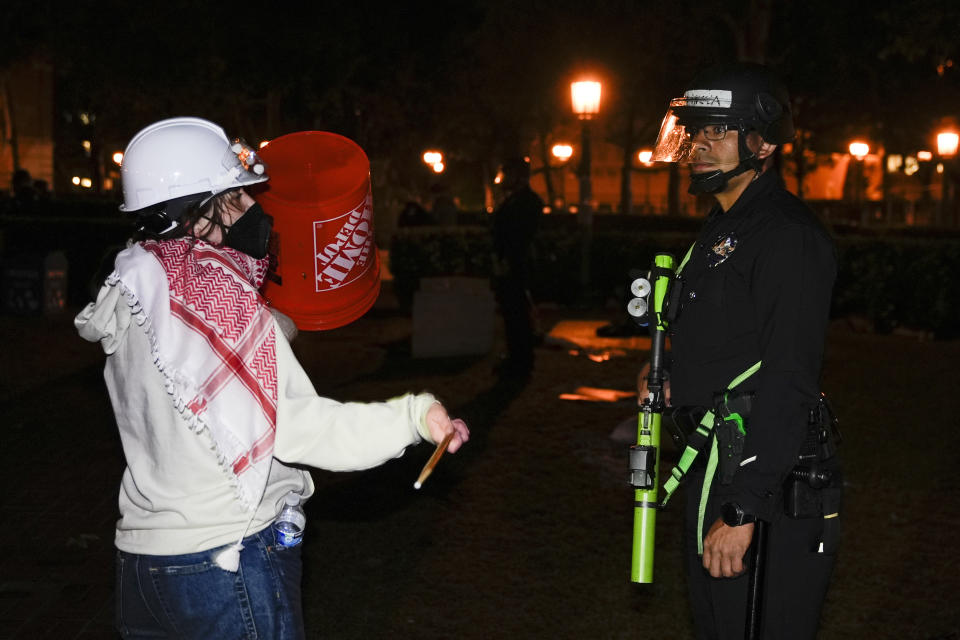 A person protests in front of a police officer after police arrived on the campus at the University of Southern California to clear an encampment set up by pro-Palestinian demonstrators Sunday, May 5, 2024, in Los Angeles. (AP Photo/Ryan Sun)