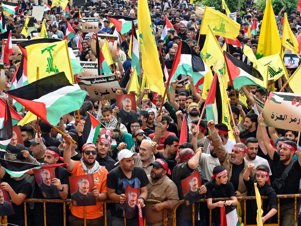 Protesters wave Palestinian, Lebanese and Hezbollah flags in Beirut (EPA)