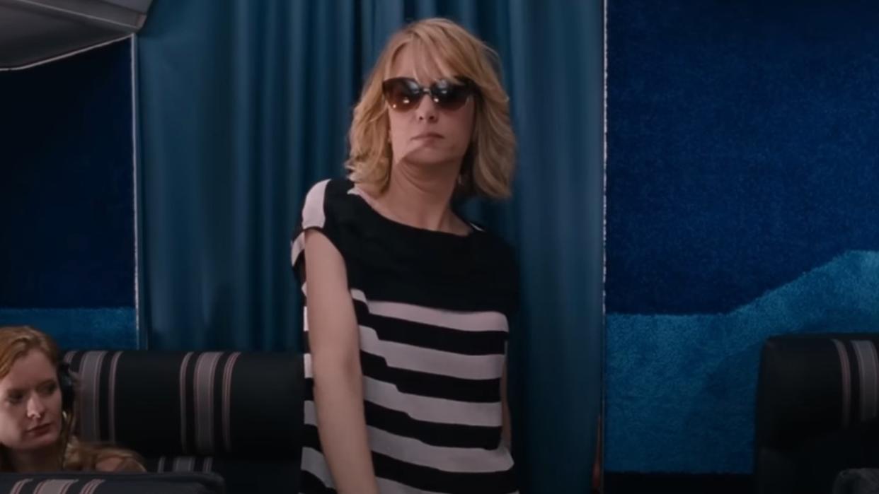  Kristen Wiig walking with sunglasses on on the plane in Bridesmaids. 