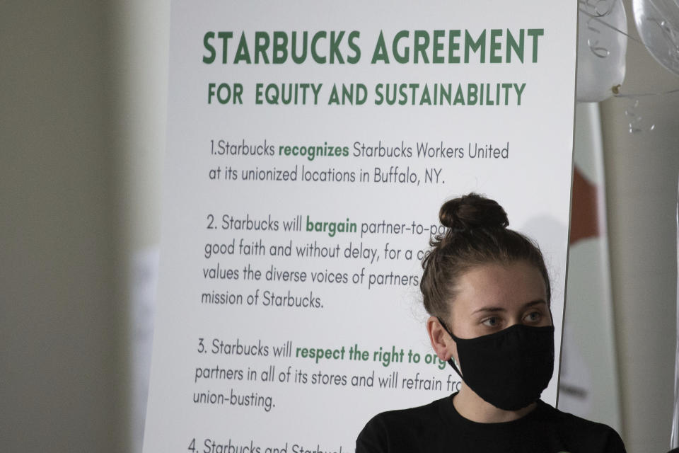 FILE - Alexis Rizzo, a Starbucks employee, stands during a press conference after their union-election viewing party Thursday, Dec. 9, 2021, in Buffalo, N.Y. It’s become a common sight: jubilant Starbucks workers celebrating after successful votes to unionize at dozens of U.S. stores. But when the celebrations die down, a daunting hurdle remains. To win the changes they seek, like better pay and more reliable schedules, unionized stores must sit down with Starbucks and negotiate a contract. It’s a painstaking process that can take years. (AP Photo/Joshua Bessex, File)