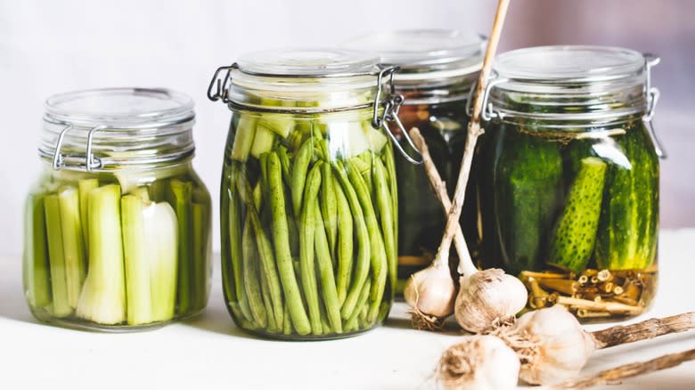 Jars of pickled celery, green beans, and cucumbers