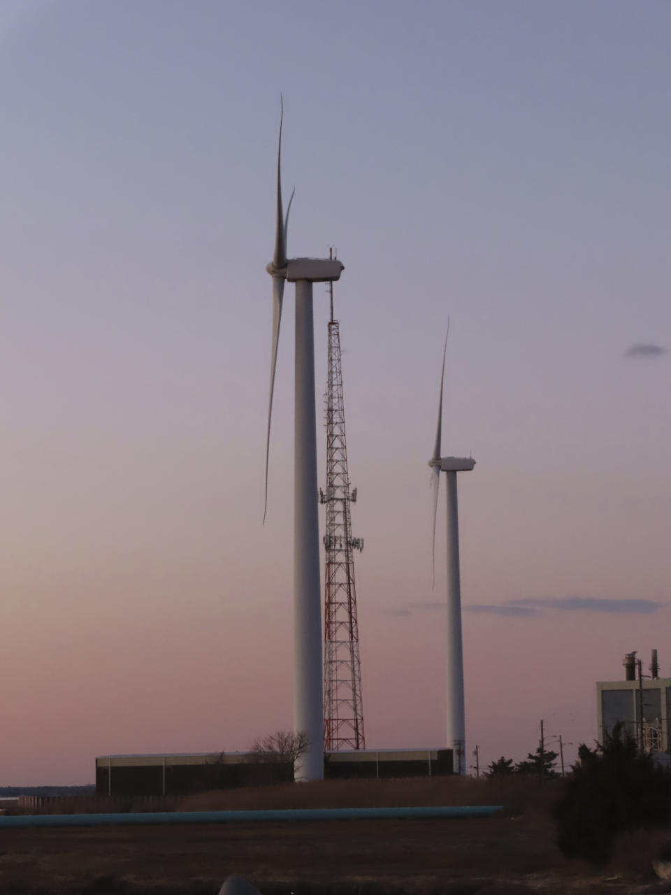 The sun sets behind land-based wind turbines in Atlantic City N.J. on Feb. 10, 2022. The U.S. Government Accountability Office on Thursday, June 15, 2023, agreed to look into the potential impacts of offshore wind energy development on the U.S. East Coast, fulfilling a long time demand from opponents of such projects. (AP Photo/Wayne Parry)