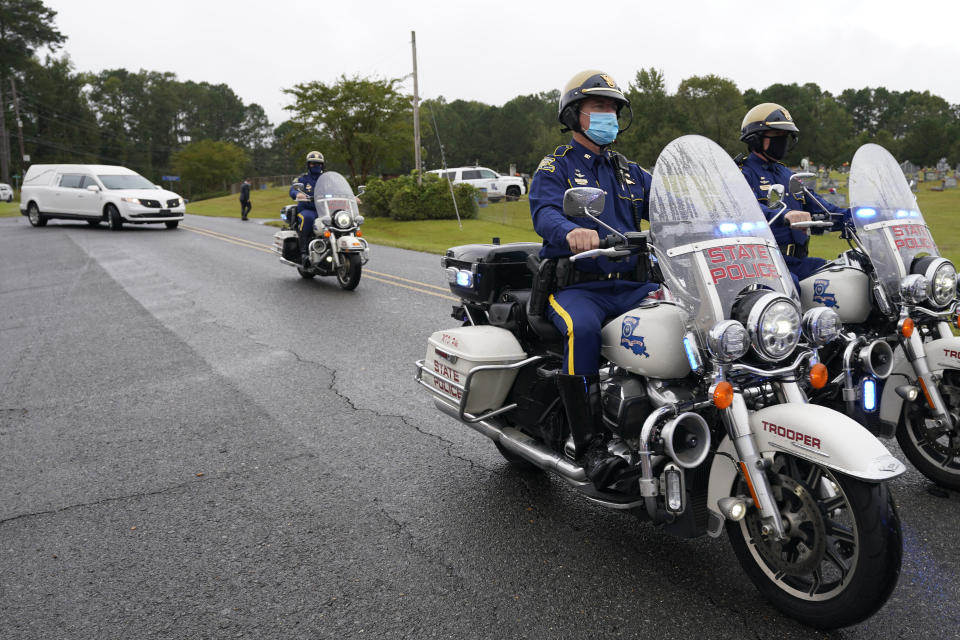 A Louisiana State Police motorcycle honor guard precedes the hearse carrying the body of Master Trooper Chris Hollingsworth, Friday, Sept. 25, 2020, in West Monroe, La. Hollingsworth, killed in a car crash hours after he was told he would be fired for his role in the death of a Black man, was buried with honors Friday at a ceremony that authorities sought to keep secret out of concerns it would attract a mass protest. (AP Photo/Rogelio V. Solis)