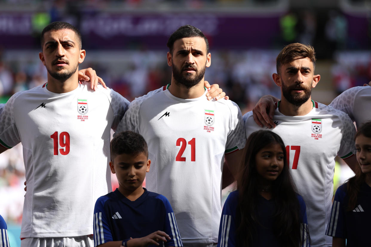 DOHA, QATAR - NOVEMBER 25: (L-R) Majid Hosseini, Ahmad Noorollahi and Ali Gholizadeh of IR Iran line up for the national anthem prior to the FIFA World Cup Qatar 2022 Group B match between Wales and IR Iran at Ahmad Bin Ali Stadium on November 25, 2022 in Doha, Qatar. (Photo by Patrick Smith - FIFA/FIFA via Getty Images)