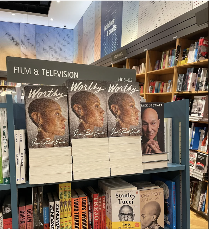 Books for sale in a bookstore. Prominent displays include Jada Pinkett Smith's "Worthy" and Patrick Stewart's "Making It So." Other books by Stanley Tucci and Quentin Tarantino