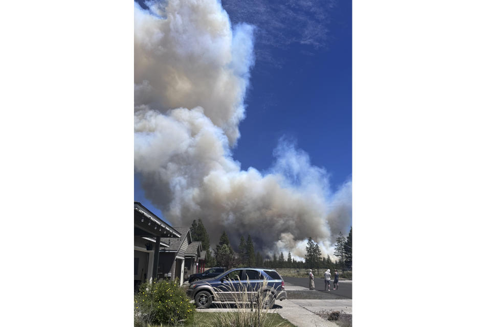 In this image provided by Jenny Braden, smoke rises from a wildfire on Tuesday, June 25, 2024, in La Pine, Ore. The wildfire near the popular vacation destination of Bend, is growing rapidly. Officials on Wednesday urged the continued evacuations of hundreds of homes in the area best known for its microbreweries, hiking, river rafting and skiing on nearby Mount Bachelor. (Jenny Braden via AP)