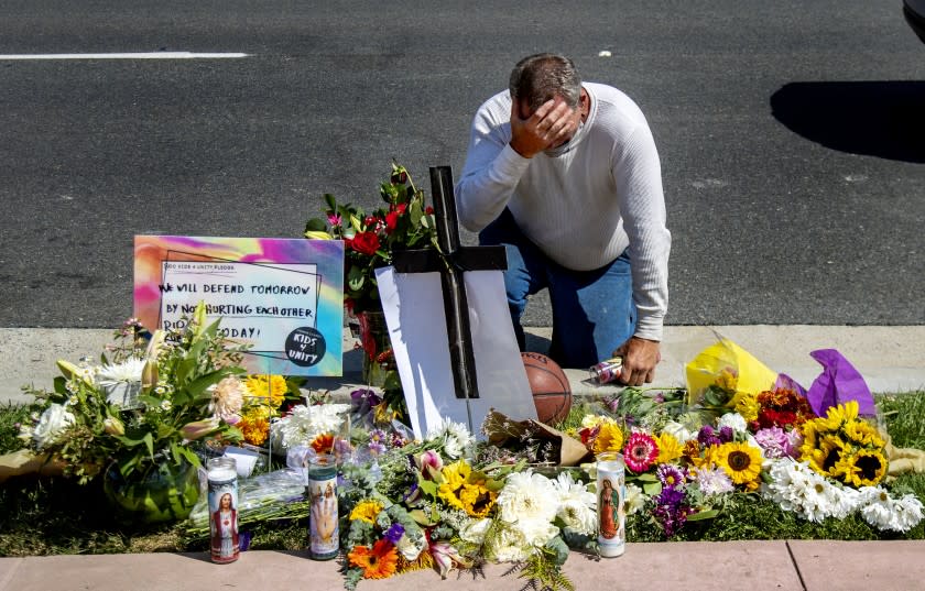 SAN CLEMENTE, CA - SEPTEMBER 25, 2020: Danny Blain is overcome with emotion as he kneels at a memorial for Kurt Andras Reinhold, a homeless Black man who was shot by Orange County deputies last week after they stopped him for jay walking and a scuffle ensued near Hotel Miramar on September 25, 2020 in San Clemente, California. (Gina Ferazzi / Los Angeles Times)