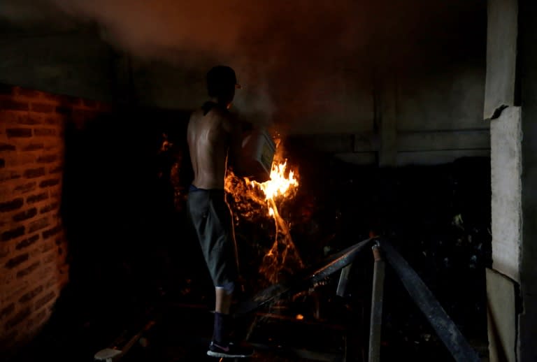 A man tries to extinguish a remaining fire in the home set ablaze