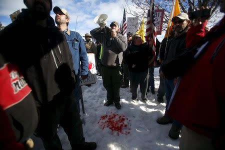 Andrew Bedortha of the Pacific Patriots Network talks on a megaphone from behind red dye meant to symbolize the blood of Robert "LaVoy" Finicum during a protest outside the Harney County Courthouse in Burns, Oregon, U.S. on February 1, 2016. REUTERS/Jim Urquhart/File Photo