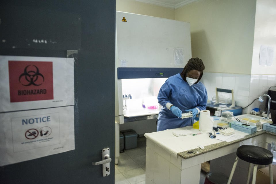 In this photo taken Friday, June 19, 2020, a laboratory specialist secures samples taken from potential coronavirus patients at the country's only laboratory that tests for the coronavirus in Juba, South Sudan. The United Nations says the country's outbreak is growing rapidly, with nearly 1,900 cases, including more than 50 health workers infected, and at the only laboratory in the country that tests for the virus a team of 16 works up to 16-hour days slogging through a backlog of more than 5,000 tests. (AP Photo/Charles Atiki Lomodong)