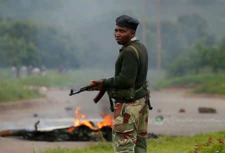 FILE PHOTO: A soldier stands before a burning barricade during protests in Harare, Zimbabwe, January 15, 2019. REUTERS/Philimon Bulawayo