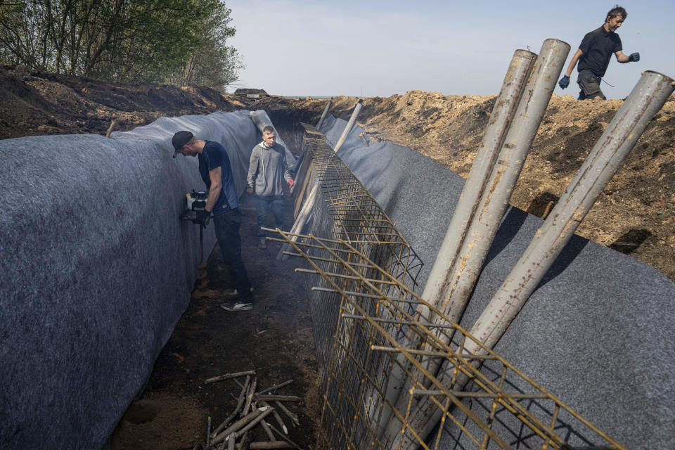 Workers construct new defensive positions close to the Russian border in Kharkiv region, Ukraine, on Wednesday, April 17, 2024. (AP Photo/Evgeniy Maloletka)