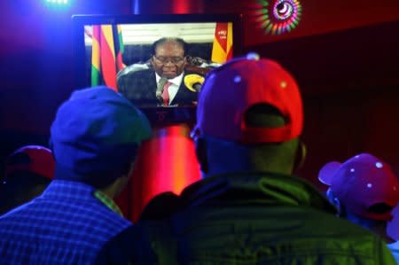 People watch as Zimbabwean President Robert Mugabe addresses the nation on television, at a bar in Harare, Zimbabwe, November 19, 2017. REUTERS/Philimon Bulawayo