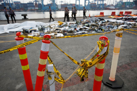 Police line is seen as Indonesian policemen walk near recovered debris and belongings of Lion Air flight JT610, that crashed into the sea, at Tanjung Priok port in Jakarta, Indonesia, October 31, 2018. REUTERS/Willy Kurniawan