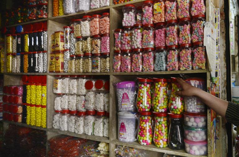 A shopkeeper arranges sweets at a wholesale market in Lahore