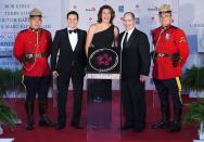 Soccer player Christine Sinclair (C) stands near her star with host Rick Campanelli (2nd L), Cineplex Chief Operating Officer Dan McGrath (2nd R), and two Royal Mounted Police Officers during Canada's Walk of Fame induction ceremonies in Toronto, September 21, 2013. REUTERS/Mark Blinch (CANADA - Tags: ENTERTAINMENT SPORT BUSINESS)