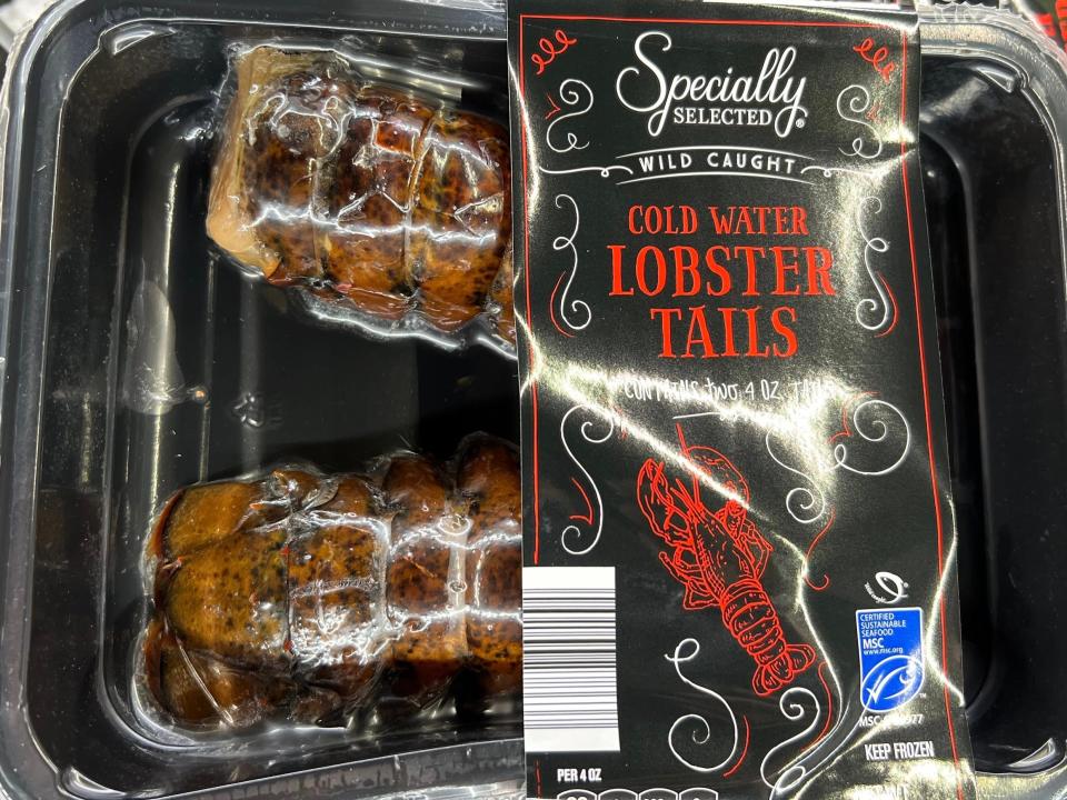 A pack of two lobster tails under plastic packaging with a black label reading "Specially Selected wild-caught cold-water lobster tails"