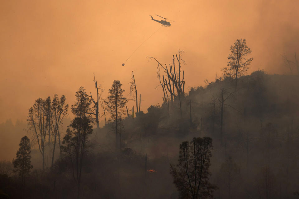 Image: Helicopter releases water on secition of LNU Lightning Complex Fire near Middletown, California (Adrees Latif / Reuters)